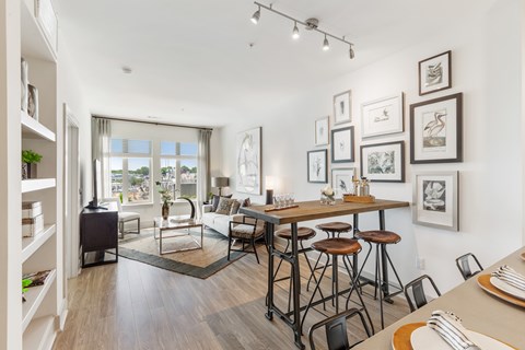 a living room with a dining room table and stools